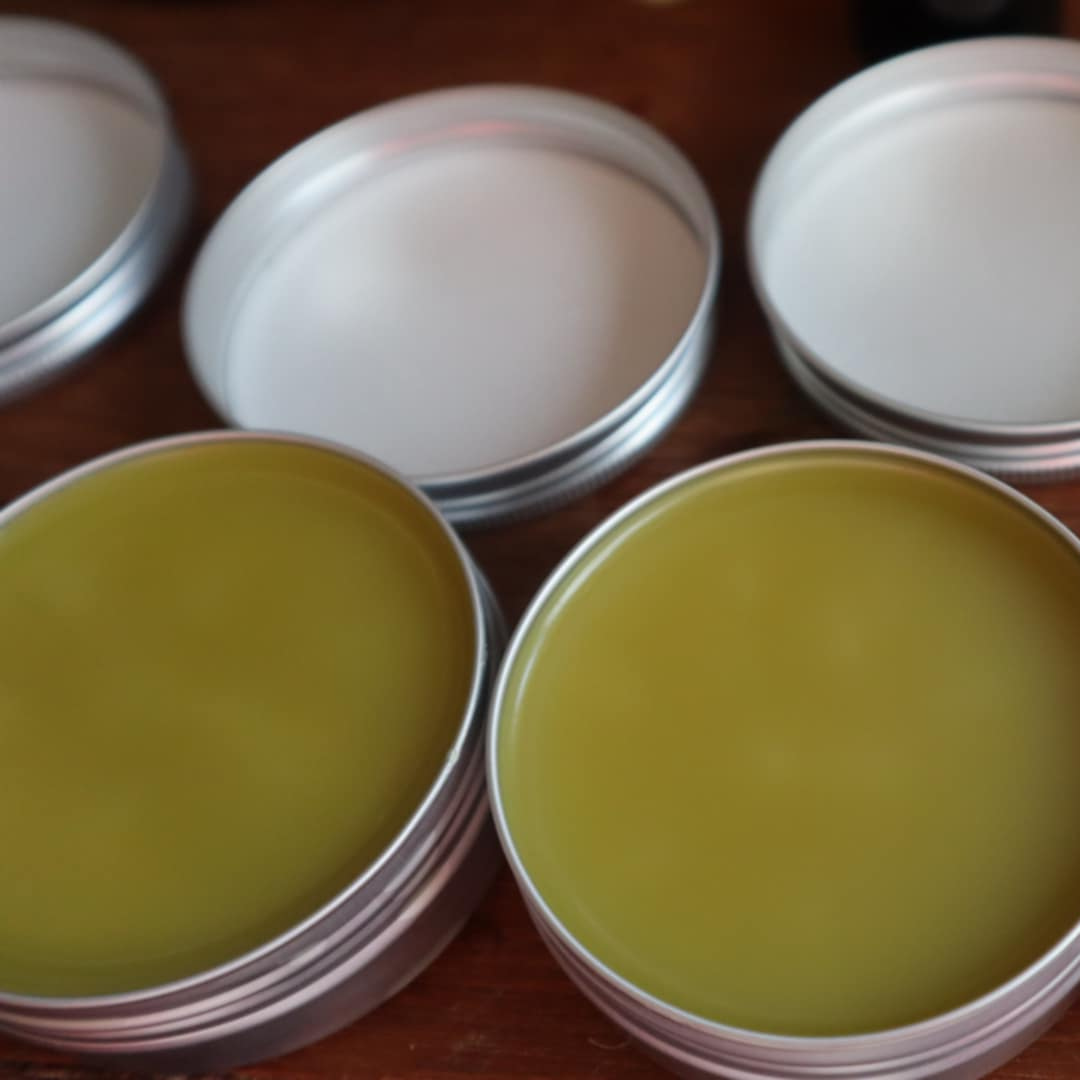 Stacks of containers of forest calm balm on a wooden surface